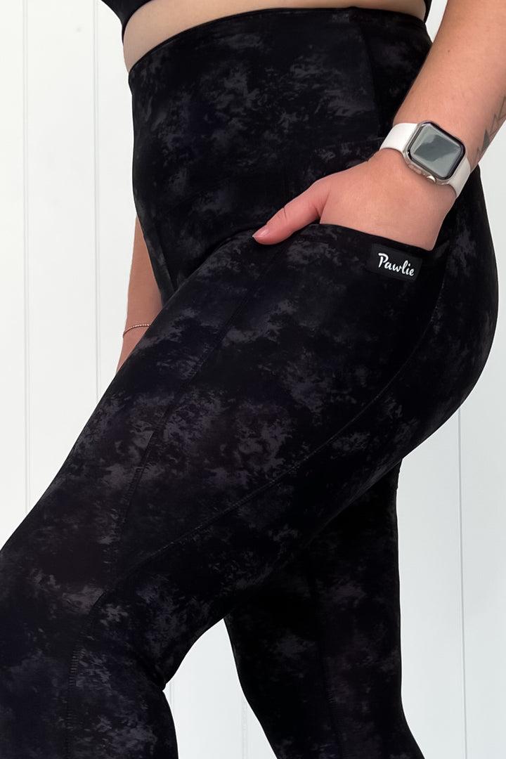 Black patterned leggings with a brand logo on a white background