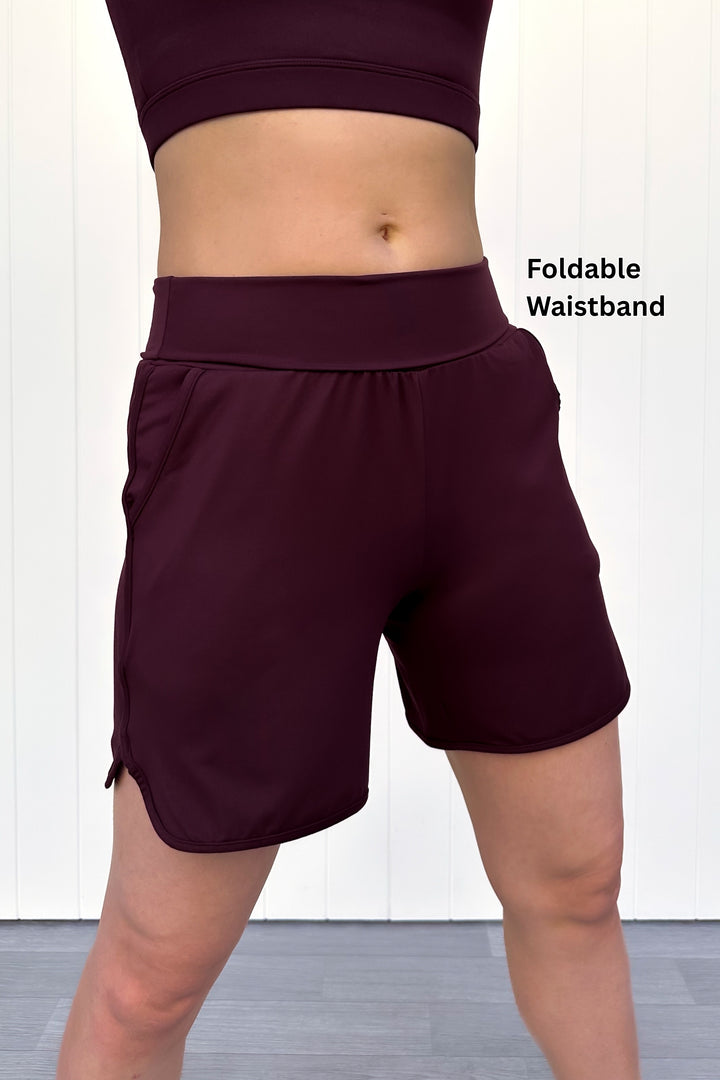 Maroon athletic shorts with a foldable waistband on a white background