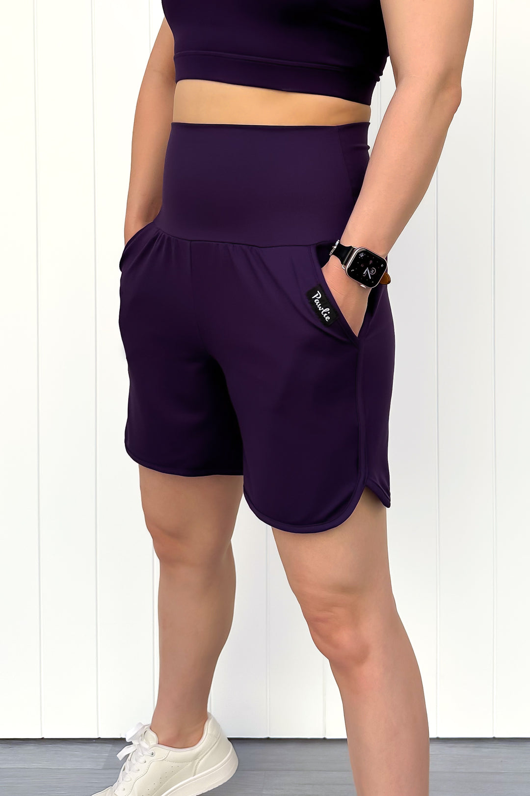 Person wearing purple athletic shorts with a white background